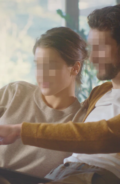 couple sitting on couch with pixelated faces